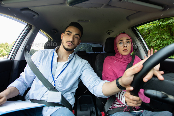 Nervous Muslim Lady In Hijab Having Driving Lesson With Instructor