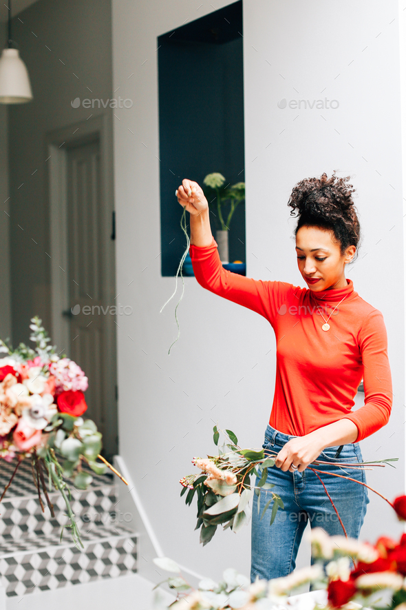 Female florist tying cut flowers in florists workshop