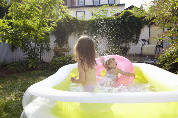 Girls having fun in inflatable pool - Stock Photo - Images