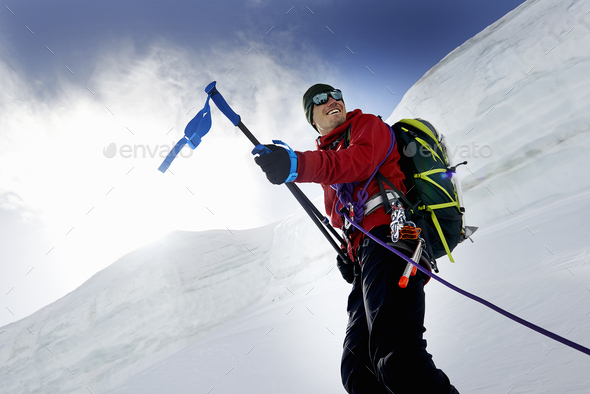 Mountaineers holding walking poles looking away smiling, Saas Fee, Switzerland - Stock Photo - Images