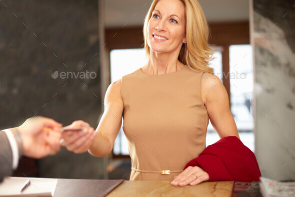 Businesswoman paying at hotel front desk