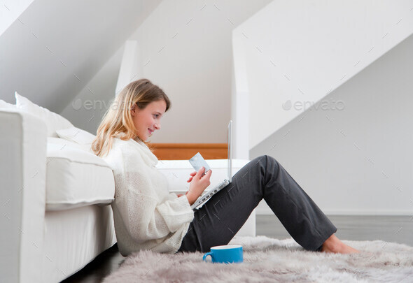 Woman shopping online in living room - Stock Photo - Images