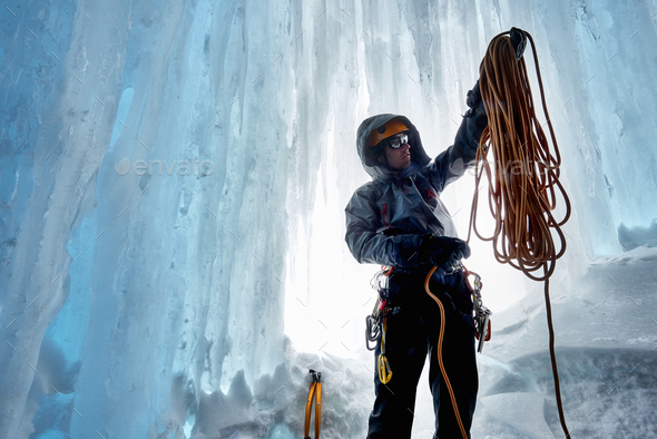 Man in ice cave preparing climbing rope, Saas Fee, Switzerland - Stock Photo - Images