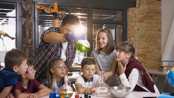 Six Young Caucasian Children with Teacher Working with Chemical Reactions at Chemistry Lab alt