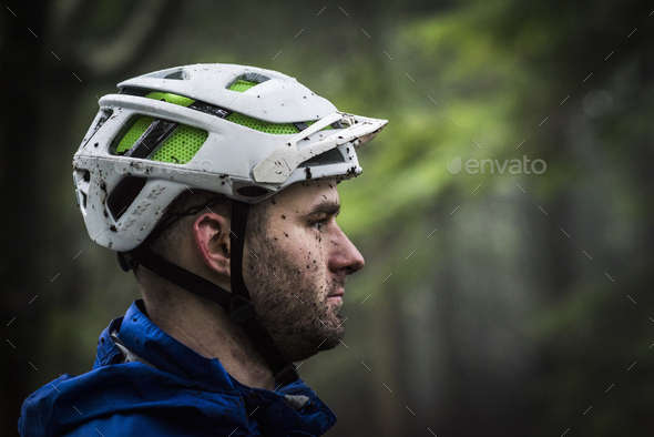 Profile portrait of male mountain biker splashed with mud