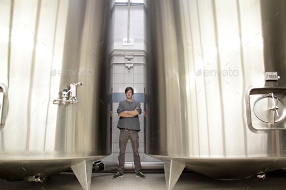 Portrait of man by vats in brewery - Stock Photo - Images