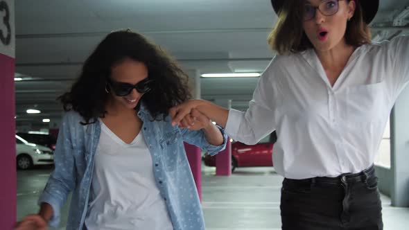 Happy Women Having Fun And Skateboarding At Parking
