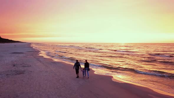 Family Walking on Beach at Sunset Slowmotion Shot
