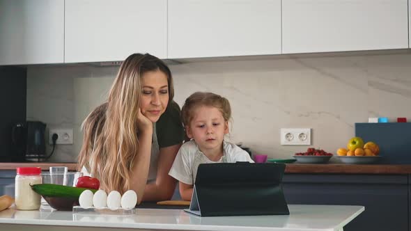 Daughter Consults Mother in Kitchen alt
