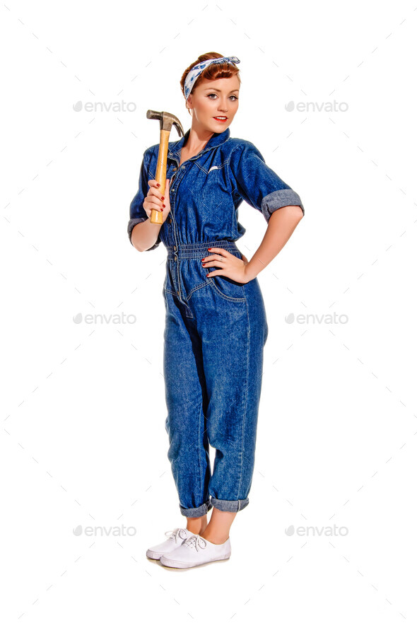 Retro-styled young woman in boiler suit with hammer