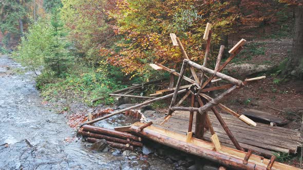 The Mill Drives the Water in the River in the Autumn Forest in Cloudy Weather alt
