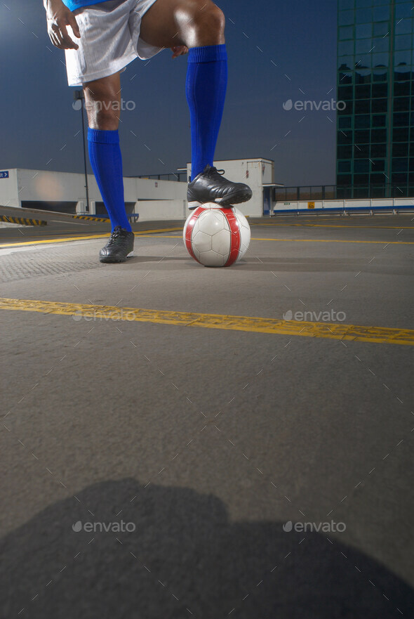 Soccer player with ball on rooftop
