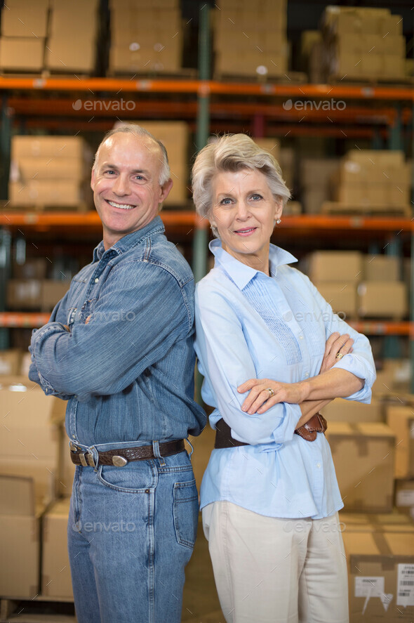 Portrait of warehouse workers back to back