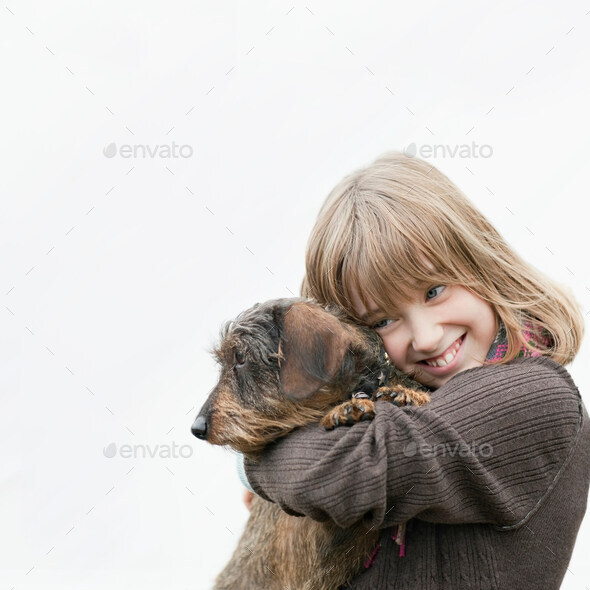 Portrait of girl embracing dog in arms