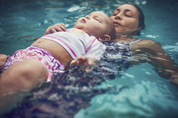 Mother and baby daughter floating on backs in water