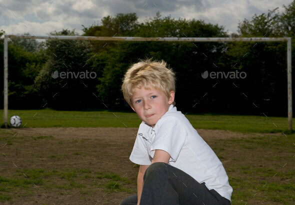 Schoolboy in front of football goalpost