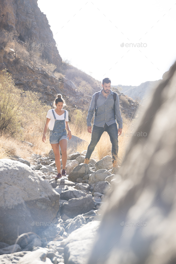 Young hiking couple hiking over rocks in valley, Las Palmas, Canary Islands, Spain