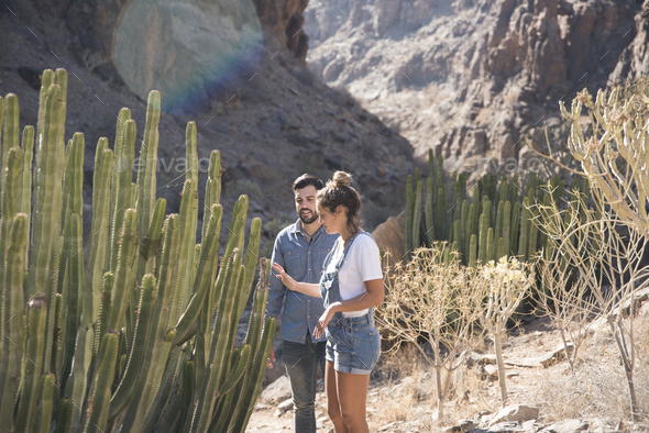 Young hiking couple looking at cacti in valley, Las Palmas, Canary Islands, Spain