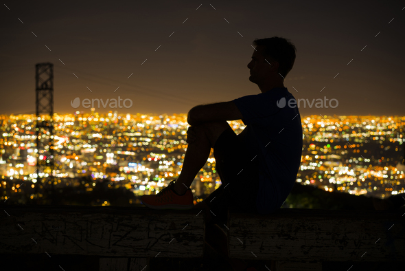 Silhouette of jogger on bench looking away at view, Runyon Canyon, Los Angeles, California, USA