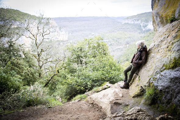 Woman leaning against rock looking away at view, Bruniquel, France