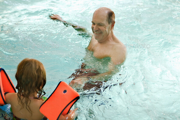 Older man swimming with grandchild