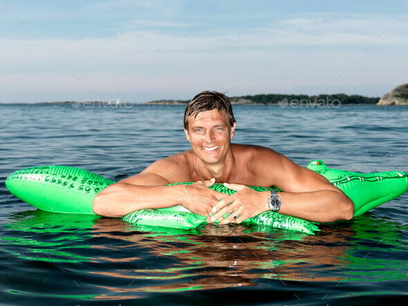Man with inflatable crocodile - Stock Photo - Images
