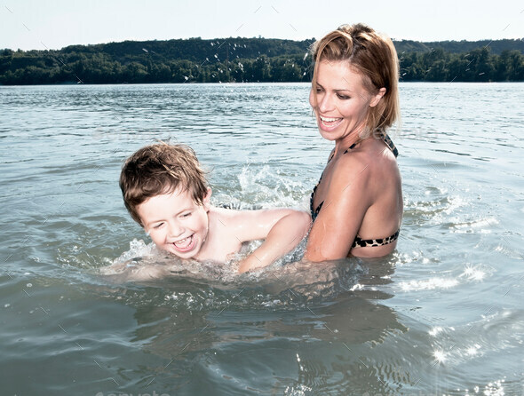 Mother teaching child to swim - Stock Photo - Images