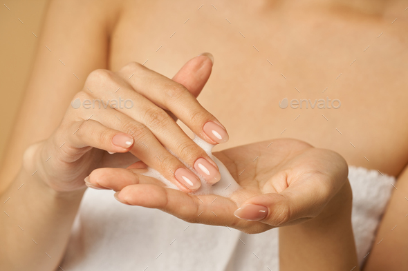 Close up of hands of woman preparing to apply gentle foam facial cleanser