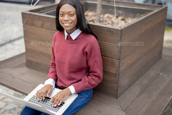 Smiling student black girl with laptop computer