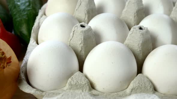 Chefs Hand Take Two White Chicken Eggs From Cardboard Eggs Tray for Cooking Breakfast alt