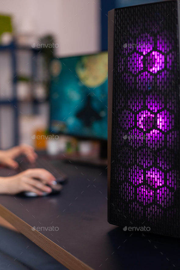 Closeup of RGB led lights system desktop, woman gamer playing space shoother video games