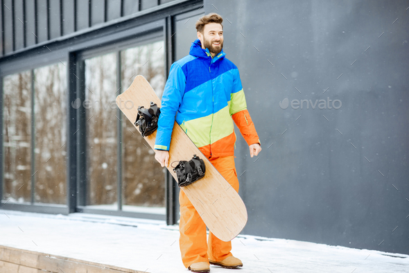 Man in ski suit near the house in the mountains