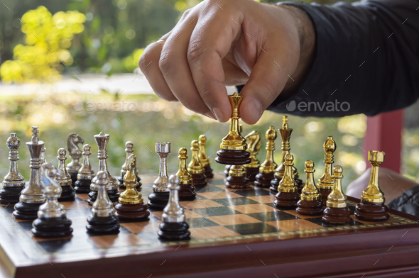 Outdoor chess game concept, leisure. The man makes a queen move. Selective focus, close-up.