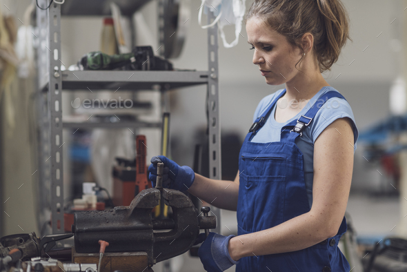 Professional female mechanic working in the garage - Stock Photo - Images