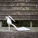 Single bridal shoe seen in profile and placed on ruined wood outdoors - PhotoDune Item for Sale