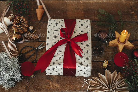 Wrapping christmas gift. Stylish festive wrapping paper, scissors, ribbons  Stock Photo by Sonyachny