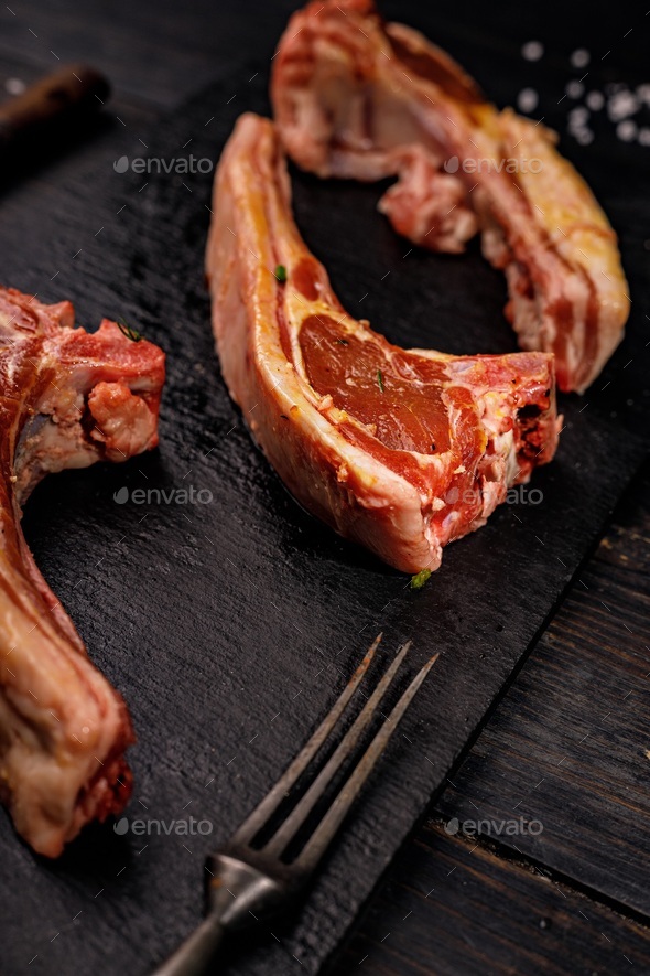 Close-up raw lamb ribs. Halal meat. Raw meat. Lamb rack on a dark rustic background