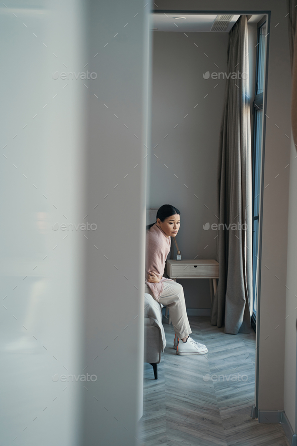 Sorrowful Asian woman spending day alone at home - Stock Photo - Images