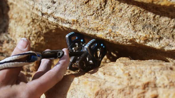 Mountaineer trying to adjust the climbing equipment alt