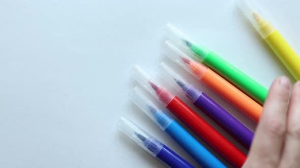 Multicolored Markers Moving on the White Background alt