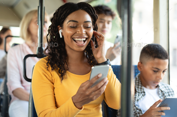 Black woman, smile and phone in social media with headphones in joy for 5G  connection in the outdoors. Happy African American female student smiling  for technology and internet on mobile smartphone