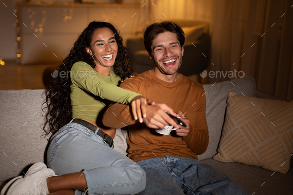 Couple Watching TV Having Fun Enjoying Comedy Film At Home