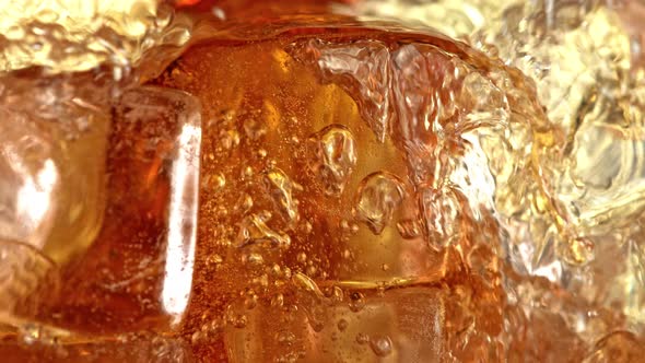 Super Slow Motion Detail Shot of Pouring Cola Lemonade Into Glass with Ice Cubes at 1000 Fps alt