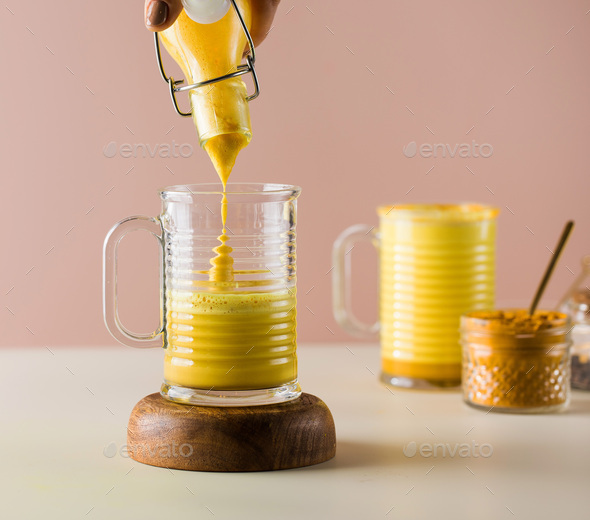 Latte turmeric on a pink background. Moon milk for better sleep