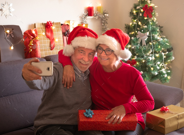 Couple Elderly Female Friends Wearing Face Mask Giving Christmas Present  Stock Photo by ©BasilicoStudioStock 430210076