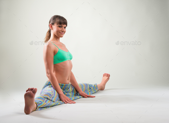Joyful young woman doing split Stock Photo by YouraPechkin