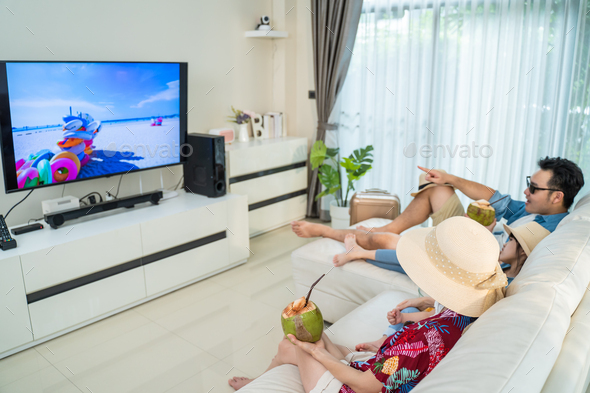 Asian Family watch TV screen, pretend on beach during summer in house.
