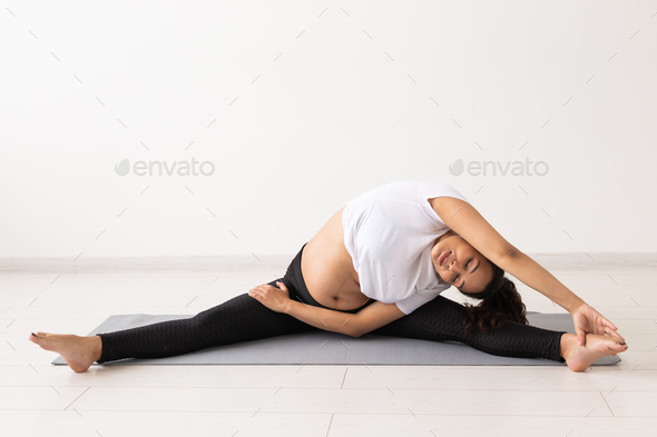 Healthy pregnant woman doing gymnastic at home. Pregnancy, healthy lifestyle and maternity leave