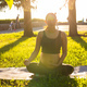 Peaceful young positive pregnant woman in gymnastic suit does yoga