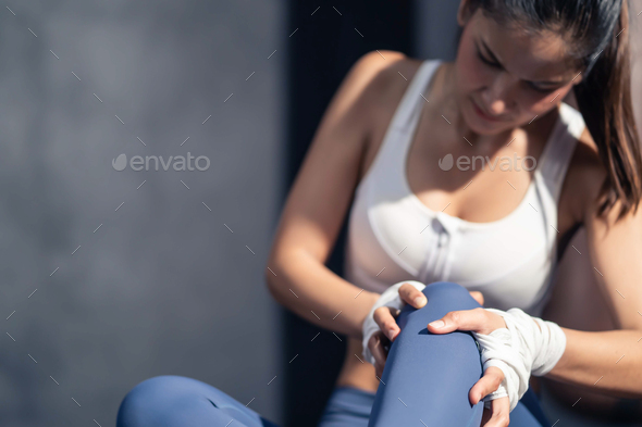 Close up of Asian athlete trainer girl get hurt from exercise in gym.